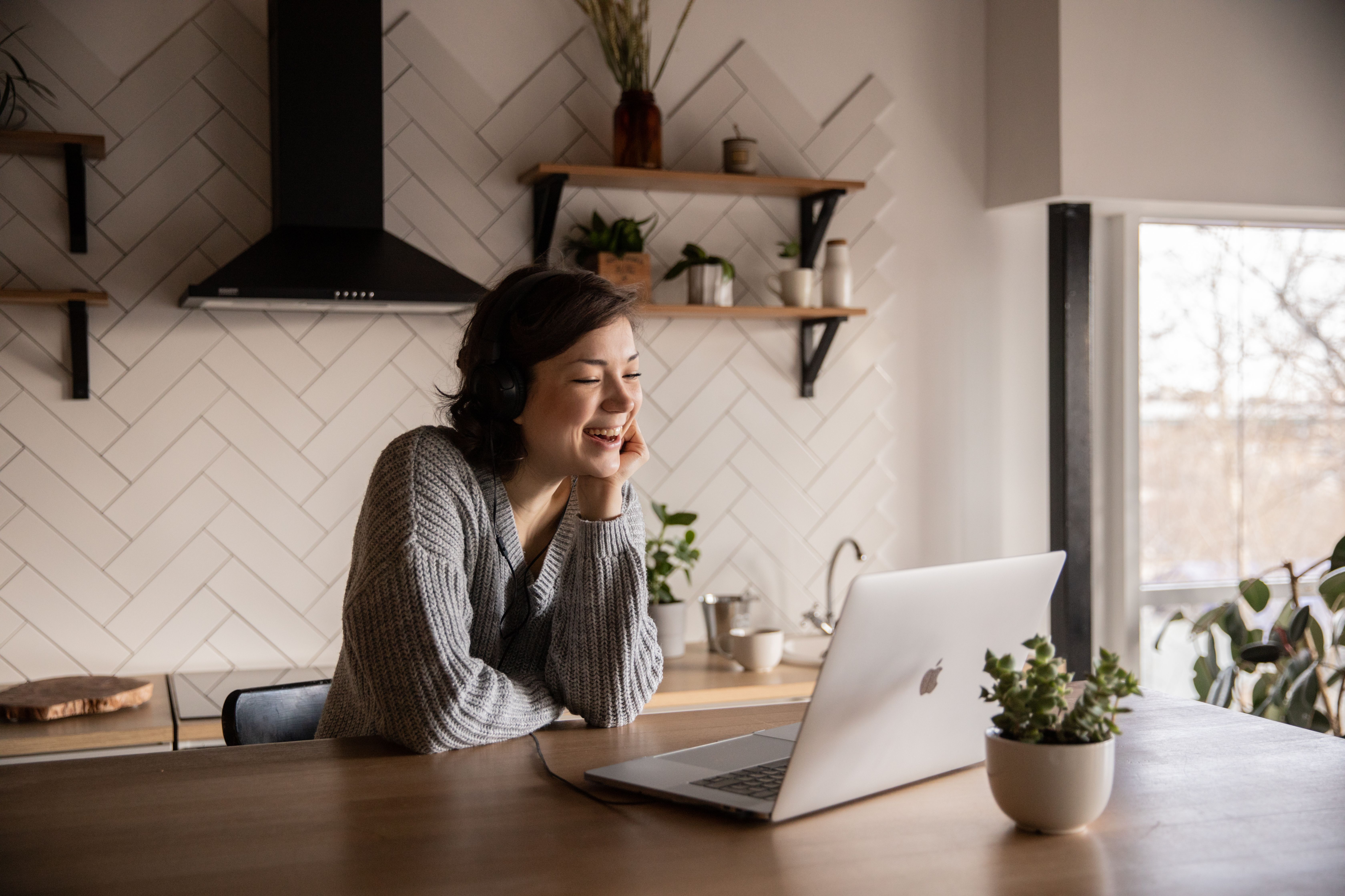 A patient on a virtual visit with her nurse practitioner from her kitchen at home.